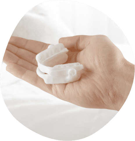 Person holding a white oral appliance in their hand